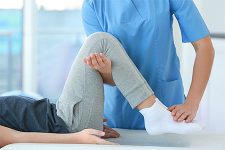 A physical therapist is assisting a patient with leg exercises